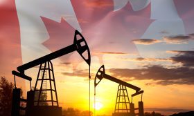 Silhouette of oil rigs against the sunset with Canada flag. Oil Industry concept
