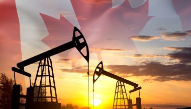 Silhouette of oil rigs against the sunset with Canada flag. Oil Industry concept